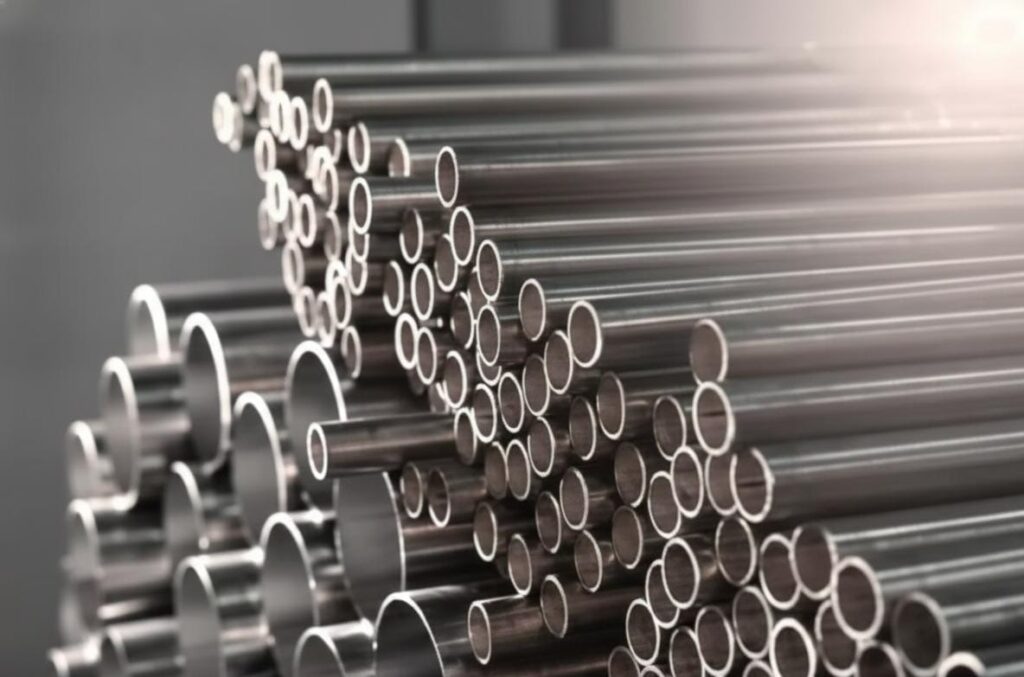 Pilha de tubos de aço inox em perspectiva, exibindo interior liso e parede maciça sem porosidade para indústria pesada.